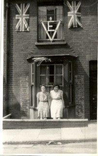 This photo was taken in 1945 when Number 16 was decorated for VE Day, my aunt and great aunt standing in front of the bay window. The drop between pavement level and the front door is just visible. | Picture by kind permission of the Jacob family