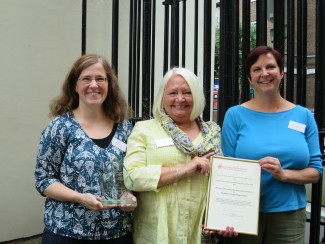 Sue Hampson, Chair of The Community Archives and Heritage Group presents Project Co-ordinator Clare (right) and Project Archivist Emily (left) with the award for 